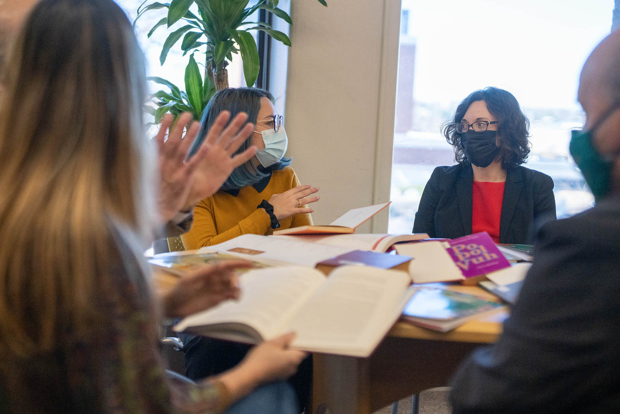 Allison Bigelow sitting at a circle table listening to colleagues